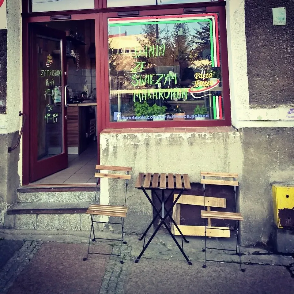 Wejście do lokalu przy Kordeckiego ze stolikiem przed witryną