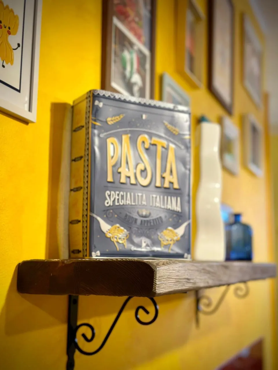Półka z puszką „Pasta specialità italiana” na żółtej ścianie